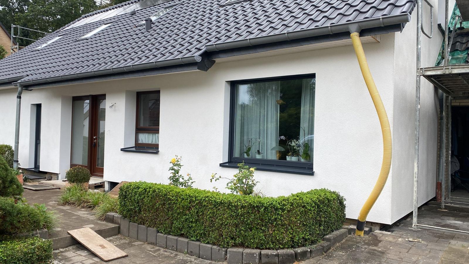 Fertiggestellter Bungalow mit weißer Putzfassade und Putz-Förderschlauch, Scherer-Putz Norddeutschland